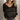Women's V-neck white striped sweater in black, size 2XL, worn by a model paired with jeans, showcasing a chic fall fashion knitwear look with visible facial features like hair, skin, lips, and eyebrows.