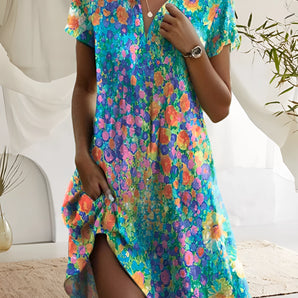 Women's short sleeve summer dress with a vibrant floral print, featuring a fitted waist and an azure color palette.