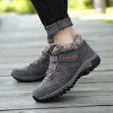 Women's black waterproof insulated hiking boots paired with grey jeans, showcasing a stylish and anti-slip design for outdoor activities.