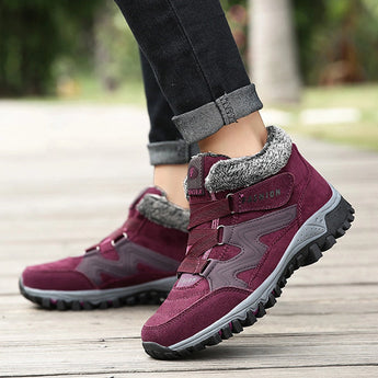Women's waterproof insulated hiking boots in shades of grey, purple, and pink with anti-slip soles, designed for outdoor walking.