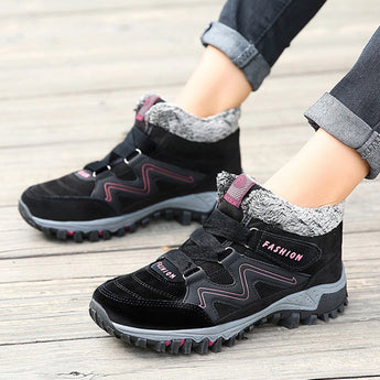 Women's stylish waterproof insulated hiking boots featuring a blend of black, blue, grey, and pink colors. The boots are designed for anti-slip performance in various terrains.