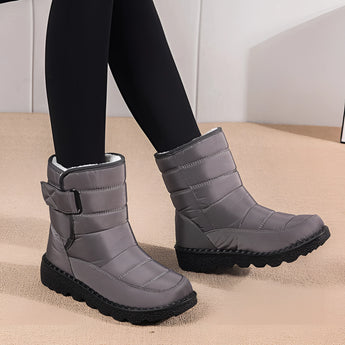 Women's waterproof insulated snow boots in electric blue, designed for non-slip traction and thermal durability, shown worn on a person's legs.