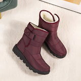 Women's waterproof insulated snow boots with a durable non-slip sole, featuring a stylish magenta and carmine color combination with synthetic rubber and leather materials, designed to keep feet warm and comfortable in cold conditions.