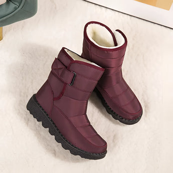 Women's waterproof insulated snow boots with a durable non-slip sole, featuring a stylish magenta and carmine color combination with synthetic rubber and leather materials, designed to keep feet warm and comfortable in cold conditions.