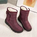 Women's waterproof insulated snow boots in a vibrant magenta color, featuring a durable and non-slip synthetic rubber sole, designed to provide thermal comfort and protection in snowy conditions.