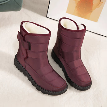 Women's waterproof insulated snow boots in a vibrant magenta color, featuring a durable and non-slip synthetic rubber sole, designed to provide thermal comfort and protection in snowy conditions.
