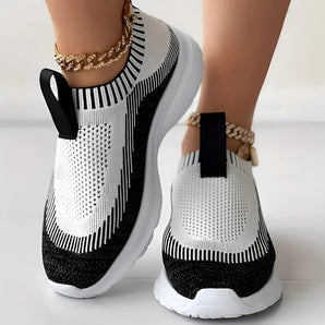 Women's white and black knit slip-on sneakers, featuring a breathable and lightweight design suitable for sportswear.