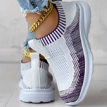 Women's white and black knit slip-on sneakers showcasing a breathable and lightweight design, ideal for fashion-forward sportswear.