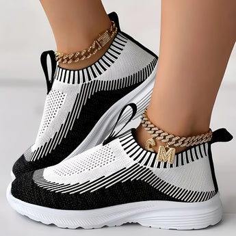 Women's white and black knit slip-on sneakers with a breathable and lightweight design, suitable for walking and outdoor activities.