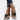 White flat sandals with rhinestone ankle chain on a woman's foot, showcasing summer fashion style.