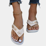 Women's white flat sandals featuring a rhinestone ankle chain, showcased on a human foot with manicured nails painted in a vibrant magenta color.