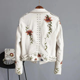 Women's white leather bomber jacket featuring intricate floral embroidery, designed with a moto style for spring.