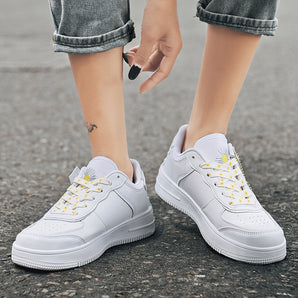White lace-up women's sneakers with a low-top design and durable sole, shown from a side angle. The sneakers are stylish and suitable for casual wear.