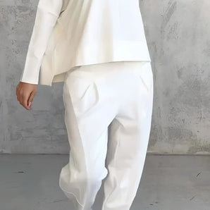 Women's white lounge set featuring a minimalist sweatshirt with long sleeves and relaxed joggers, showcasing a comfortable and stylish design.