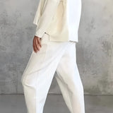 Women's white lounge set featuring a minimalist sweatshirt and relaxed joggers.