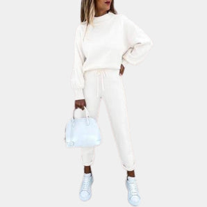 A woman wearing a white loungewear set consisting of a relaxed-fit sweatshirt and joggers. The set is in a size 2XL, emphasizing comfort and style suitable for athleisure.