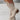 Women's white perforated studded cowgirl ankle boots in the Cachi color variant, size 43, showcasing a stylish summer western design with detailed perforations and studs, worn by a model standing barefoot.