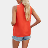 A woman wearing a white pleated high neck blouse paired with distressed denim shorts, showcasing the upper body and leg features of the clothing.