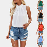 
A women's fashion ensemble featuring a white pleated high neck blouse paired with distressed denim shorts.