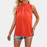 Women's white pleated high neck blouse with long sleeves paired with distressed denim shorts, featuring a stylish look with attention to shoulder and waist fit.