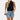 A woman wearing a white pleated high neck blouse paired with distressed denim shorts.