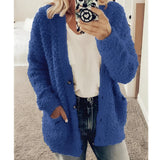 
A woman wearing a soft plush women's teddy coat in white, styled as a fluffy winter cardigan. The coat features a collar and full sleeves, suitable for cold weather. She is also wearing sunglasses, adding a stylish touch to the cozy outerwear. The image highlights the warm and comfortable texture of the jacket.