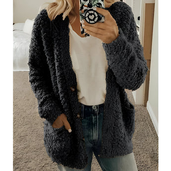 Women's black teddy coat, soft plush fabric, oversized fit, featuring a fluffy texture and long sleeves, styled with a fashionable look.