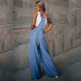 Women's wide-leg blue denim overalls featuring pockets, displayed with focus on the leg and waist areas.