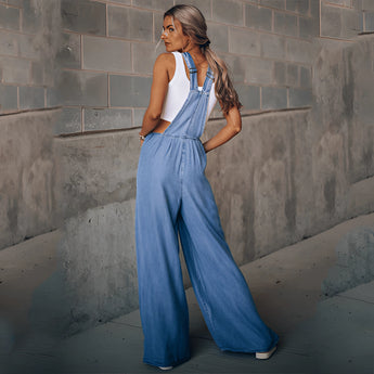 Women's wide-leg blue denim overalls featuring pockets, displayed with focus on the leg and waist areas.