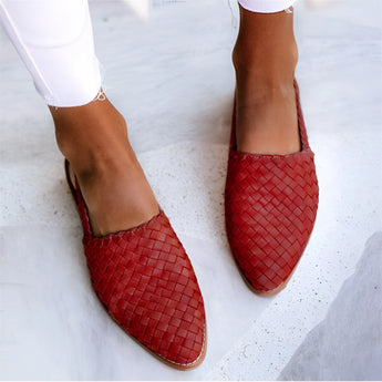 Stylish red woven leather loafers for women, shown on a foot, highlighting the slip-on design.