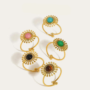 18K gold plated women's ring featuring a unique design with gemstone, displayed on a plant background.