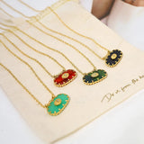 A luxury emerald necklace featuring a green gemstone pendant on a gold chain.