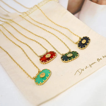 A luxury emerald necklace featuring a green gemstone pendant on a gold chain.