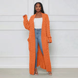 Orange oversized cable knit cardigan sweater for women with long sleeves and a cozy design.
