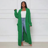 
A green oversized cozy cable knit cardigan for women, featuring a detailed knit pattern, long sleeves, and a relaxed fit.