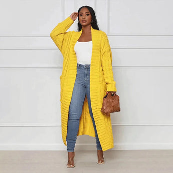 Yellow oversized cable knit cardigan for women, featuring a cozy texture and loose fit, shown in size 2XL. The cardigan has a prominent collar, long sleeves, and extends to the thighs, styled over a pair of denim pants.