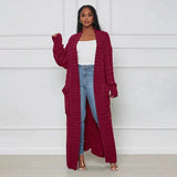 
Image of a woman wearing a burgundy oversized cable knit cardigan sweater, featuring a cozy design with long sleeves and an open front. The sweater has a loose fit, suitable for a comfortable and relaxed style.
