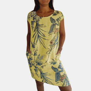 Yellow floral tropical print women's summer dress with pockets in size 3XL, featuring short sleeves and a flowy fit, worn by a model showcasing the dress's vibrant colors and comfortable design.