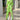 A model wearing a green floral wrap dress with a v-neck and high-low hemline, featuring a tropical print. The dress highlights the shoulders and waist, with short sleeves and a fashionable design, suitable for formal or stylish occasions.