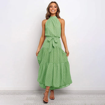 Yellow polka dot halter neck tiered maxi dress with a flowing silhouette, showcasing a stylish summer look.