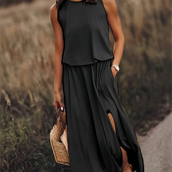 A woman wearing a black sleeveless maxi dress with a high slit, suitable for summer beachwear, standing with hands on hips, visible waistline and flowing fabric.