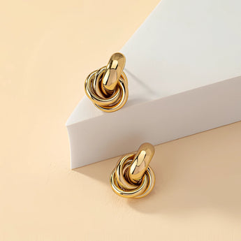 Gold spiral earrings with multiple loops, showcasing modern and luxurious designer craftsmanship, made from high-quality metal.