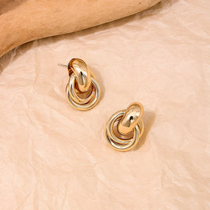 Gold spiral earrings with multi-loop design, modern luxury designer jewelry.