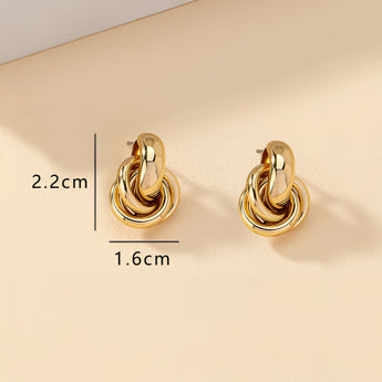 Gold Spiral Earrings featuring modern, luxury, multi-loop design in gold metal, resembling spirals and circles, high-end designer jewelry.